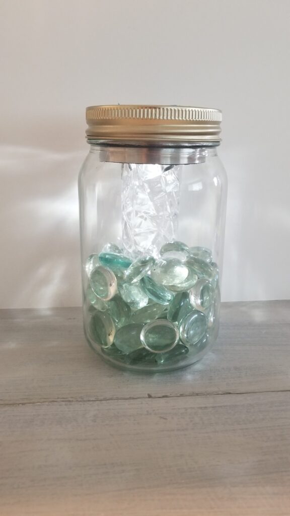 glass jar with lid encasing the solar light inside with acrylic beads