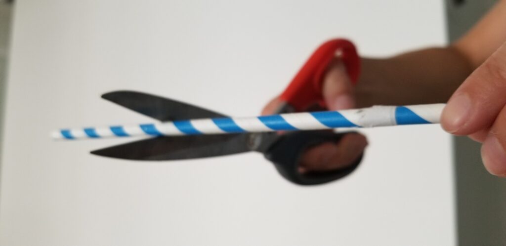 scissors cutting a drinking straw