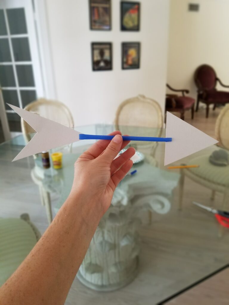 stick the arrowhead and tail cutouts into straw slits