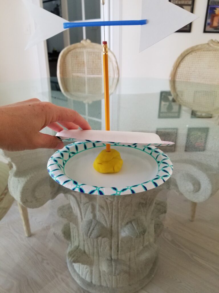 pencil stuck through paper plate and into play-doh