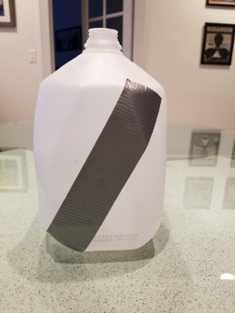A milk jug with a strip of duct tape on it