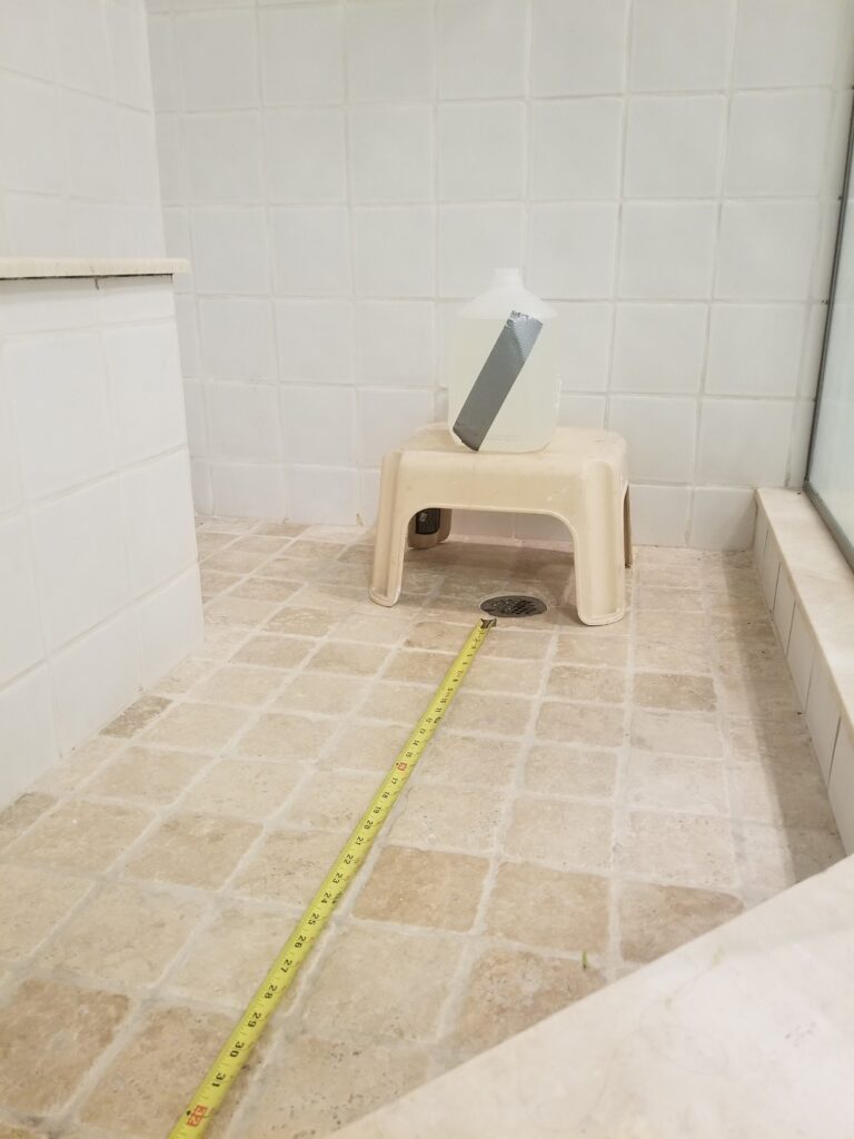 Milk jug is on top of a step stool in the shower.