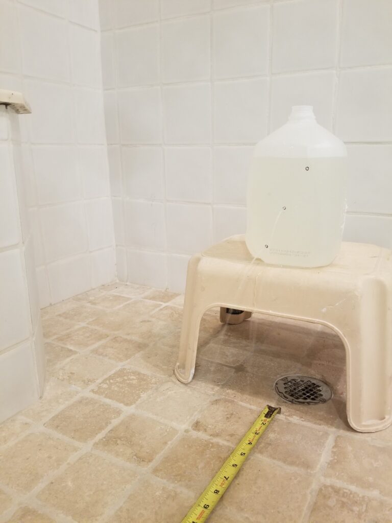 Recording the length of the water stream from the milk jug with a tap measure.