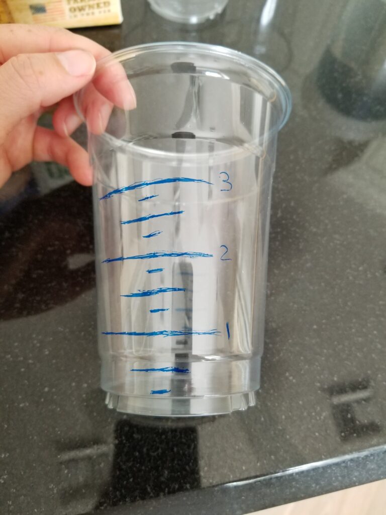 plastic cup with drawn inch markers