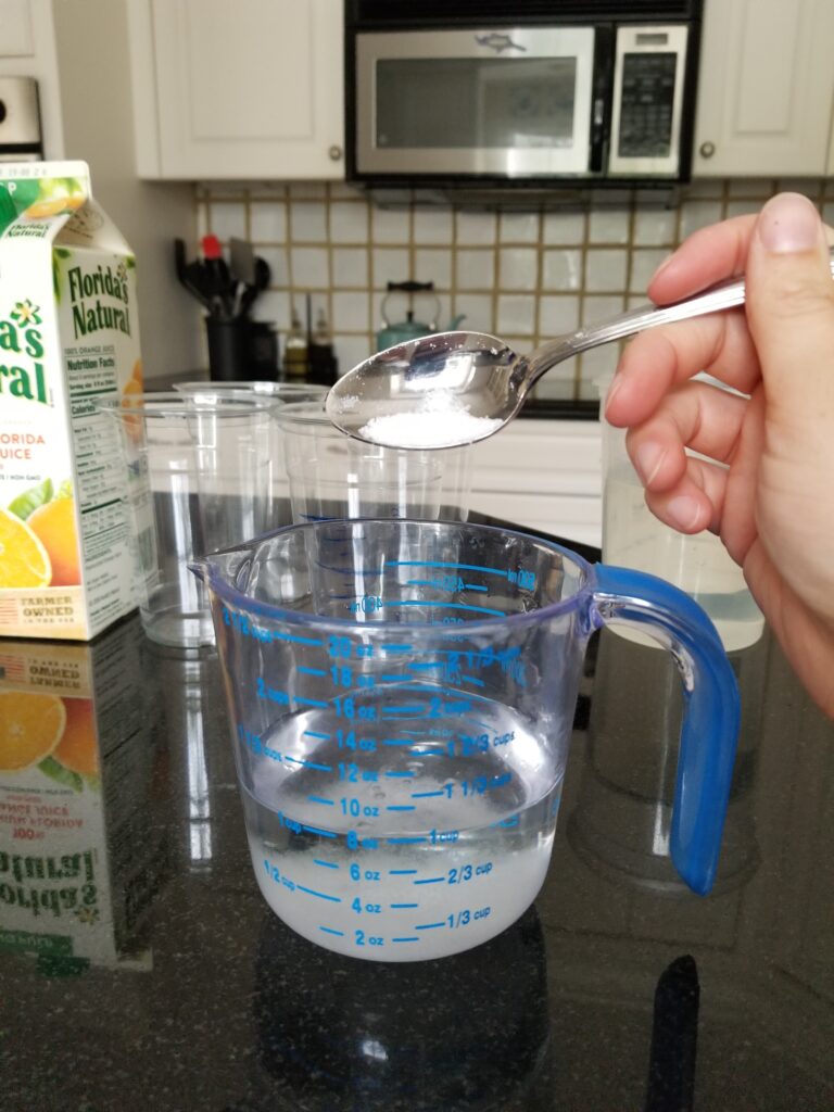 adding salt to cup of water