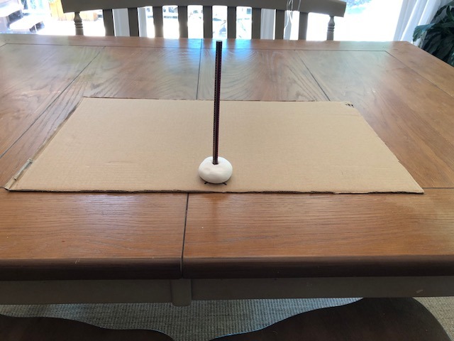 modeling clay and pencil glued to cardboard