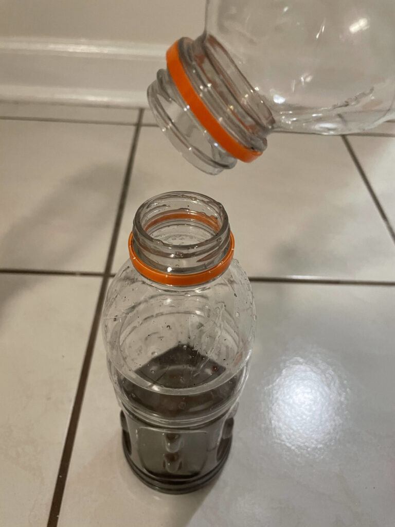 plastic bottle emptying into other bottle