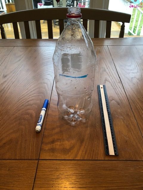 plastic liter bottle with blue marker and ruler next to it