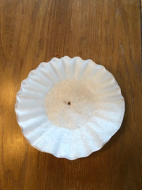 two coffee filters together with a small hole in the middle