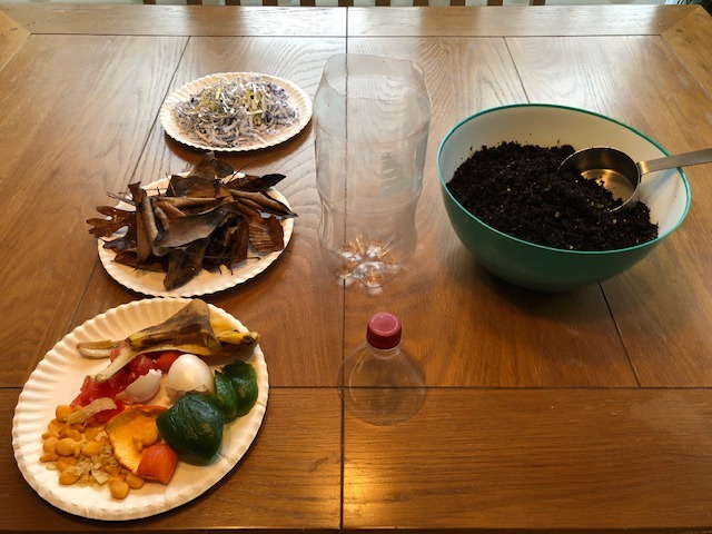 organic materials on paper plates and a bowl full of potting soil