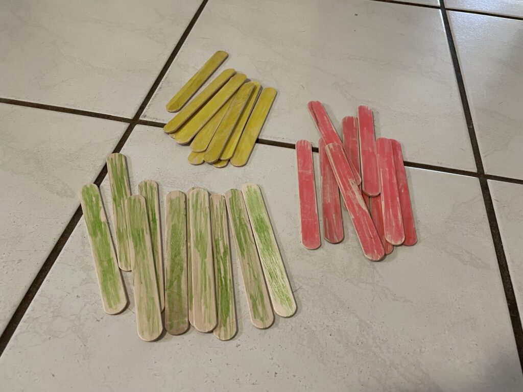 Three piles of colored popsicle sticks