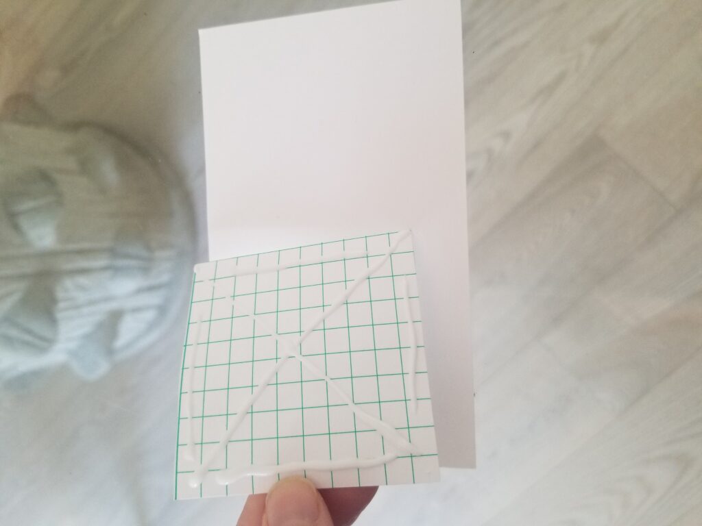 grid paper with glue on it over white paper
