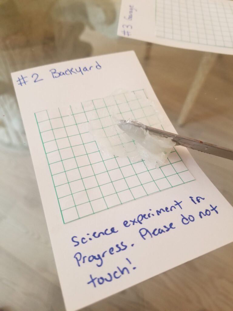 butter knife spreading petroleum jelly on top of grid paper