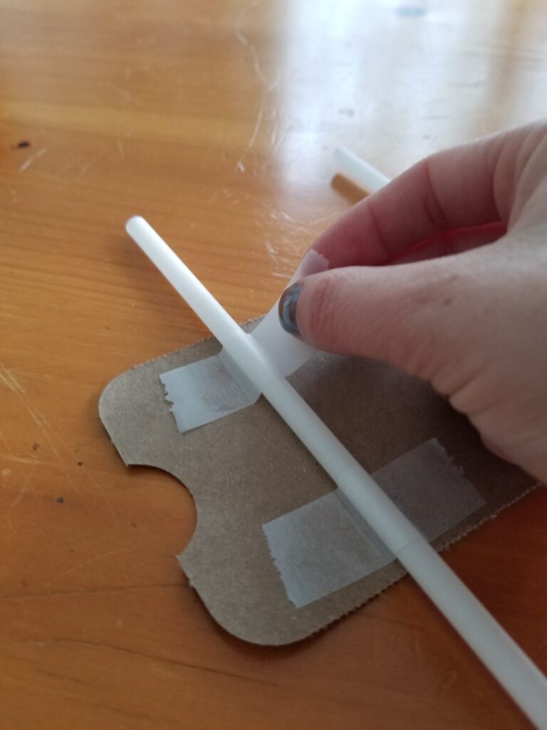 taping straw to cardboard